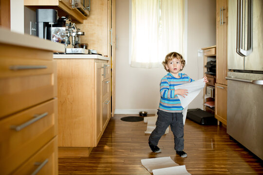 Toddler in kitchen with paper towels
