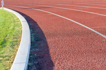 Obraz premium Part Red plastic track in the outdoor track and field stadium.Close-up.