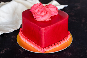 Red cake in heart shape on dark background