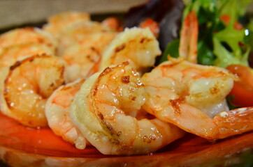 fried roasted shrimps in plate with wegetables