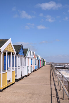 Row of brightly coloured beach huts on the seafront at Southwold.