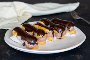 Chocolate eclair cake on dark background
