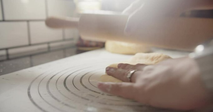 Slow motion Close up hands of bakery Chef preparing flour and kneading roll out dough with a rolling pin on the table, Ingredients and preparation stages for cooking making bread cake at kitchen