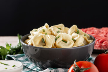 Pelmeni dumplings on rustic wooden table.Typical russian food	