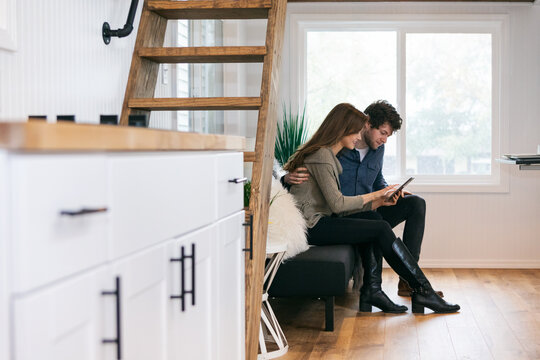 Home: Couple Relaxes On Couch Looking At Tablet Computer