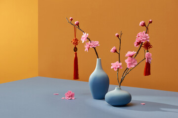 Spring peach flowers blooming in vase isolated on color with lucky knot