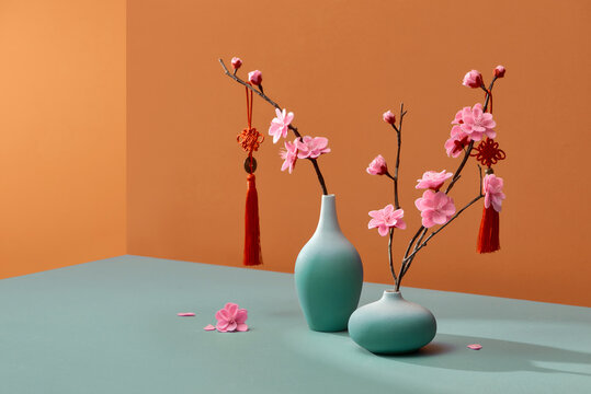 Flowering Branches In Vase With Lucky Knot Isolated On Color