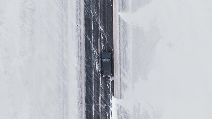 Overhead view Of a brand new black Car on a winter road