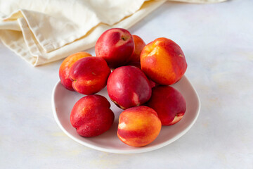 Ripe fresh nectarine on a white ceramic plate