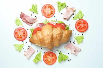 Croissant sandwich and ingredients on white background, top view