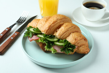 Concept of tasty eating with croissant sandwich on white background