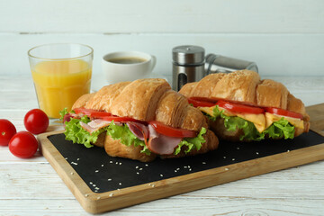 Concept of tasty eating with croissant sandwich, close up