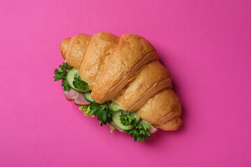 Tasty croissant sandwich on pink background, top view