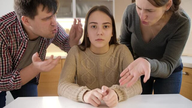 Teenage girl crying and closing face with hands after conflict with parents. Family violence, conflicts and relationship problems