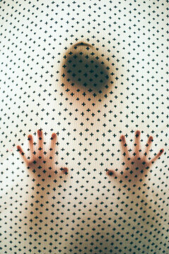 Creepy young child hides behind sheet 