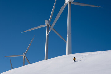 a  person skiing at a wind farm