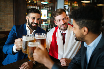 People, men, leisure, friendship and celebration concept. Happy male friends drinking beer at pub