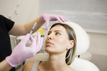 Pretty woman in a cosmetologist cabinet