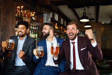 Business men in pub cheering for a sporting event