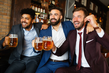 People, men, leisure, friendship and celebration concept. Happy male friends drinking beer at pub