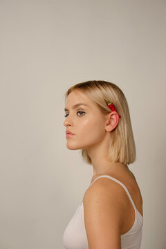 Portrait of sweet blonde girl with chilli pepper over her ear