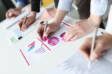 Group of business people writing with ballpoint pens in documents with graphs closeup