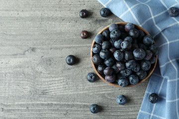 Bowl of fresh blueberry on gray textured background