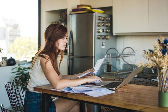 Woman reviewing invoices at home