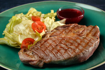 grilled steak with salad leafs and sauce