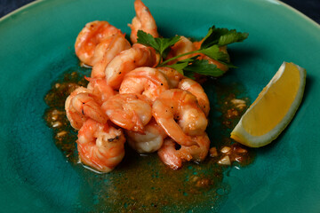 fried roasted shrimps in plate with lemon greens parsley garlic