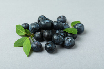 Fresh blueberry with leaves on gray background