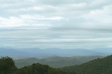 Obraz premium A photograph from a mountain peak in Asia. The early morning clouds that had not yet shined on the undulating mountains.