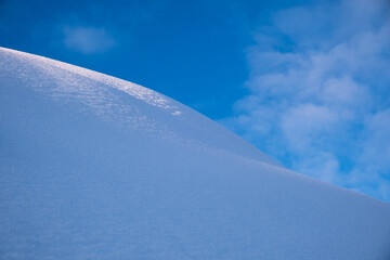 rounded snow dune and blue sky