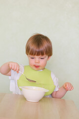 Happy cute infant baby boy spoon eats itself