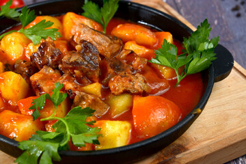 Goulash, beef stew with potatoes on pan closeup
