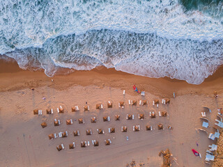beach view from above, top down landscape of ocean wave and umbrellas on sand, Portugal