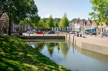 Geervliet, The Netherlands, June 12, 2021: view across the harbour towards the central market square with traditional houses and linden trees