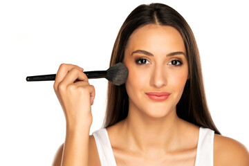 Obraz premium woman is applying powder with a makeup brush