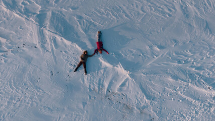 overhead shot of couple lay in the snow