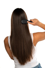 rear view of a young woman brushing her straight long hair