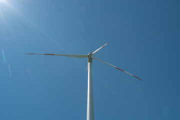 Big wind turbine to generate electrical power as green ecofriendly energy at blue deep sky and...