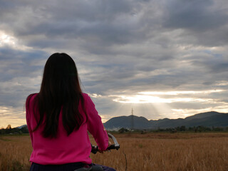 Naklejka premium Woman Standing back with her bicycle looking nature
