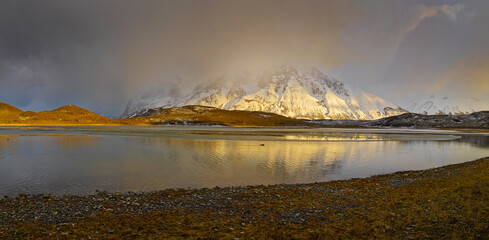 Winter landscape in Patagonia: sunrise over snow covered Paine mountain range partly shrouded in fog
