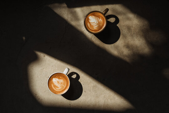 A cup of Coffee latte on the Cement floor in sunlight