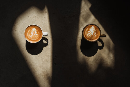 A cup of Coffee latte on the Cement floor in sunlight