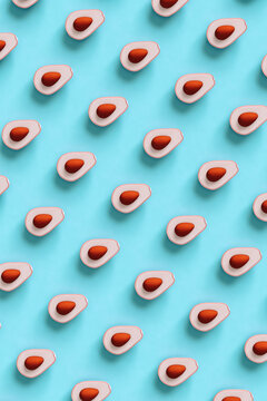 top down view of Pink avocados on blue background