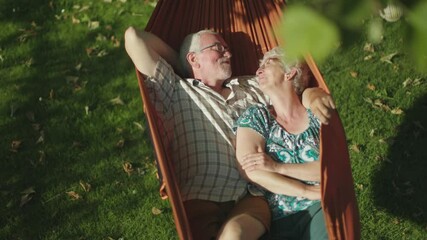 senior couple bonding on the hammock. free time together. positive retired people. - Powered by Adobe