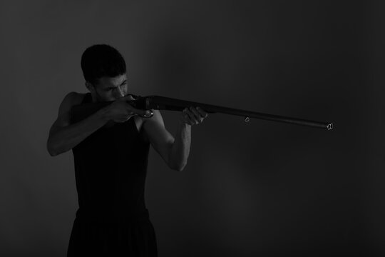 Man with vintage shotgun in black and white