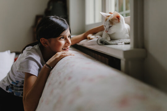 Teen girl at home with cat 