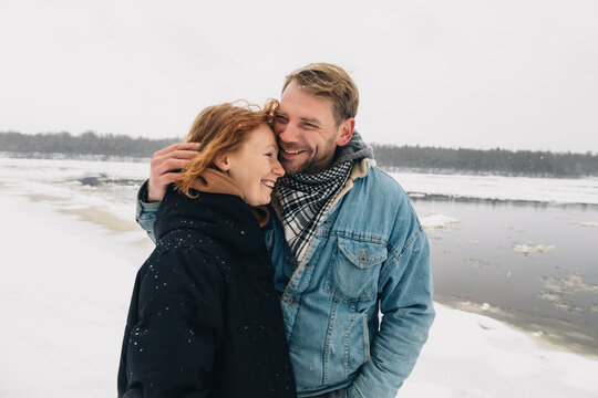 Spouses on winter river bank